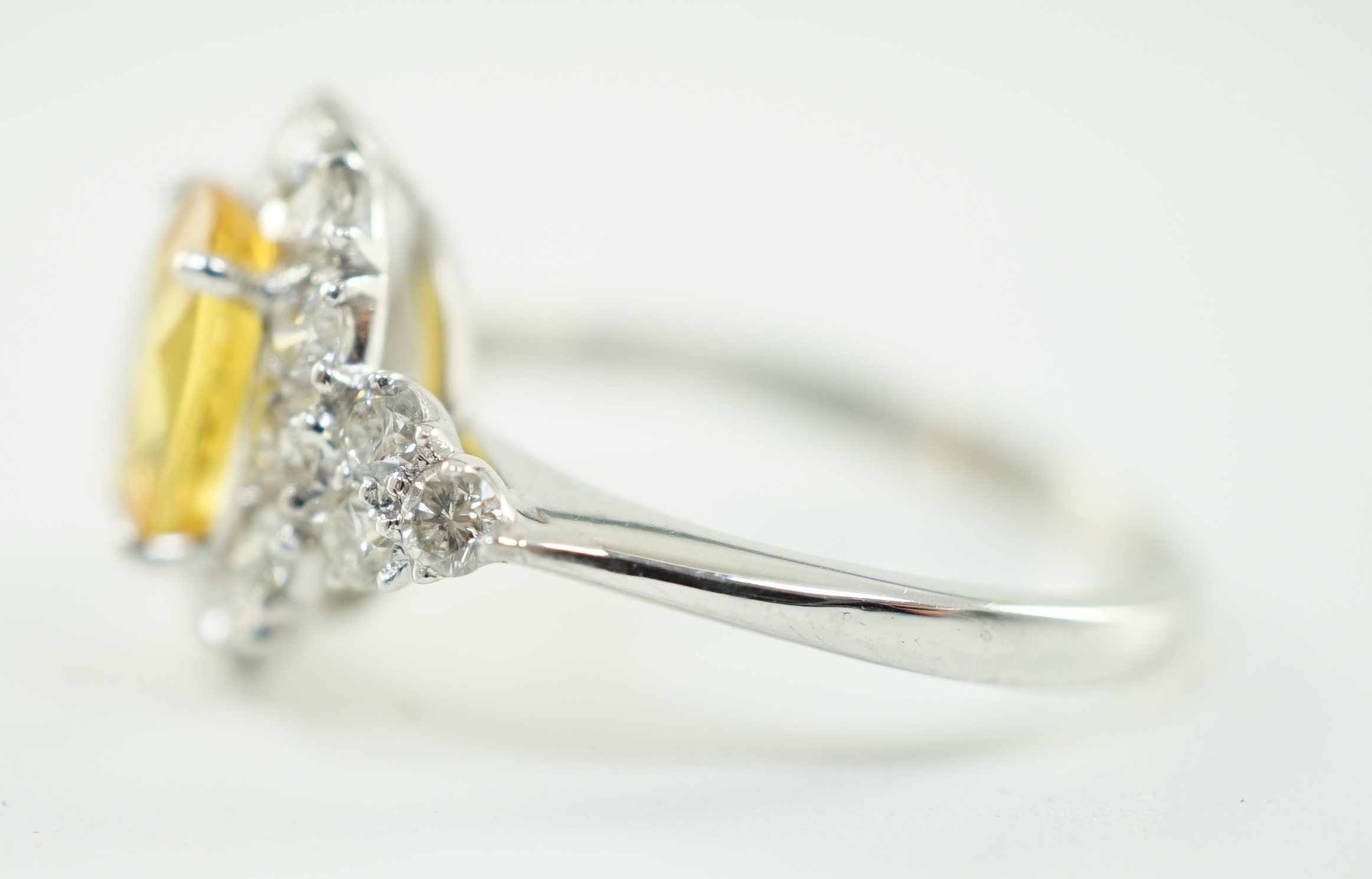 A modern 18ct white gold and single oval cut yellow sapphire set ring